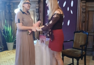 Dyrektor wręcza kwiaty pisarce