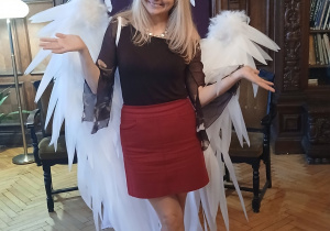 Pisarka Monika Tarwid ubrana w duże skrzydła anioła