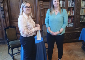Dyrektor biblioteki wręcza upominek autorce Paulinie Rosińskiej